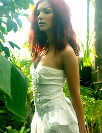 A redhead nymph slowly strips off her dainty dress, revealing a smooth fair complexion and gorgeous physique that stands out from the lush, green surroundings.